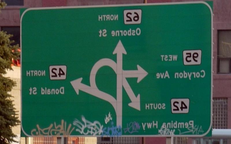 著名的“困惑角”路标，上面有四个重叠的箭头，每个箭头都指向如何导航到不同的道路