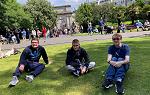 Three students sitting on St. Stephens Green on first day of the 爱尔兰 2024 study abroad trip