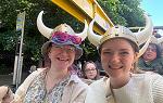 Two students smiling while wearing viking helmets
