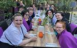 前往德国留学的学生们坐在户外餐厅的长桌旁微笑着拍照